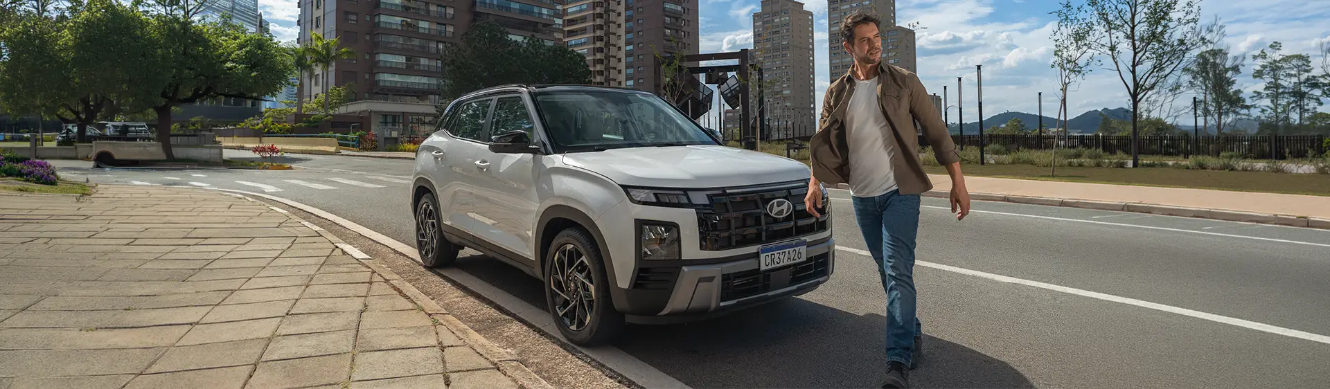 Novo CRETA Ultimate estacionado após baliza com homem atravessando na frente do veículo durante o dia.