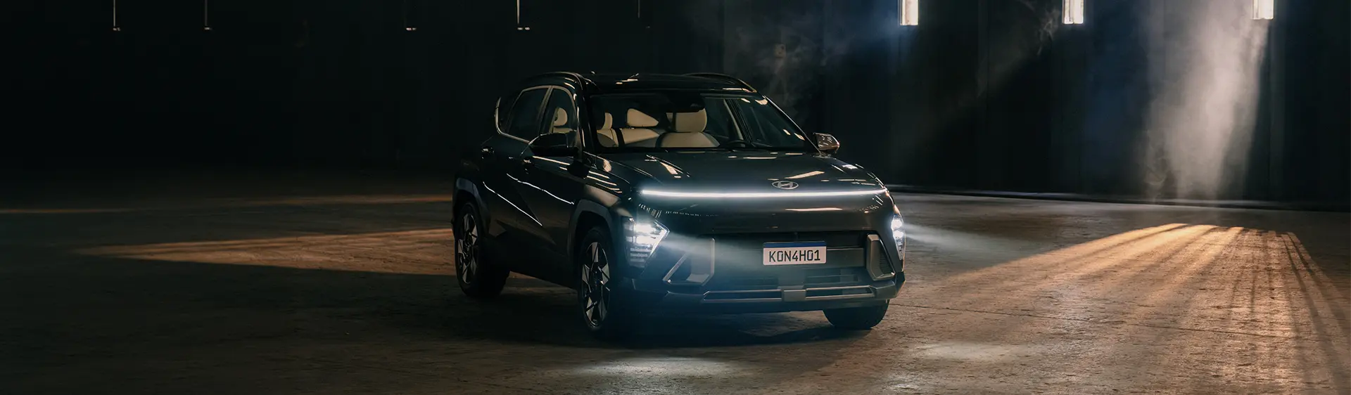 KONA Híbrido estacionado em galpão com conjunto de luzes em LED aceso.